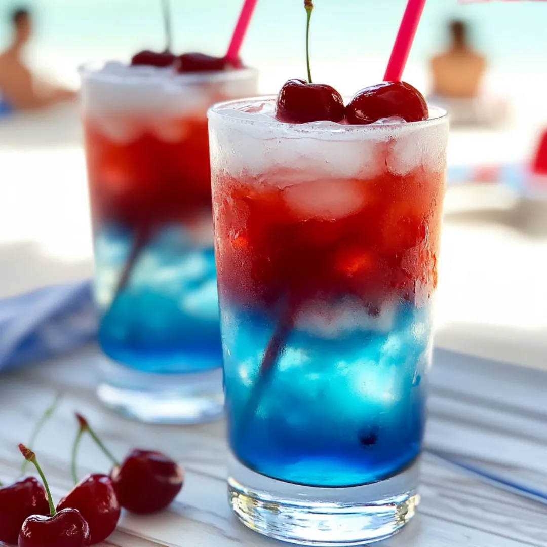 Two glasses filled with cherry limeade and fresh cherries beside them.