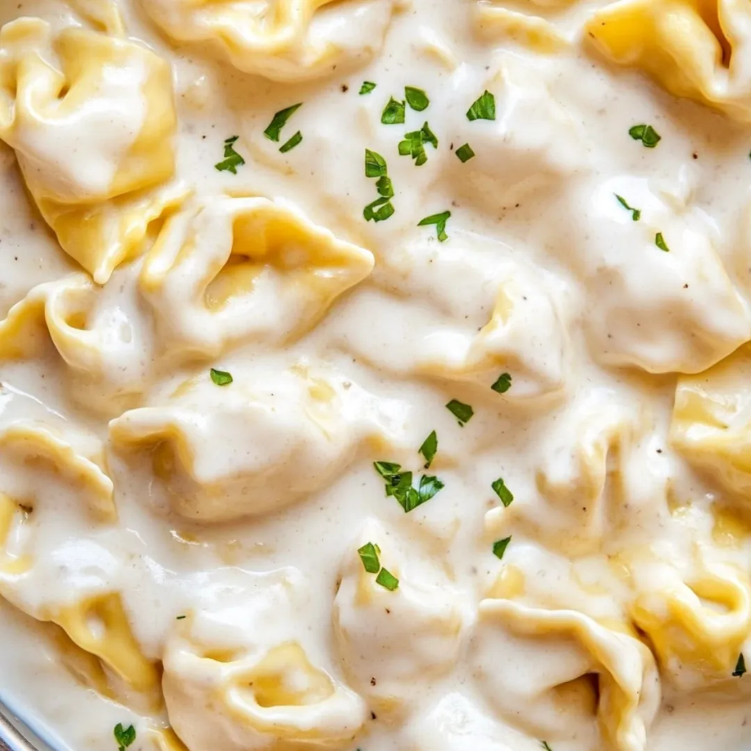 A bowl piled high with pasta and a sprinkle of fresh herbs.