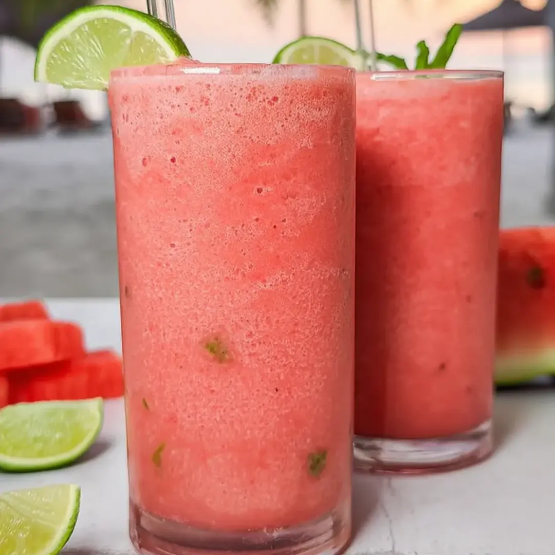 Two glasses showing off a bright pink fruity smoothie.