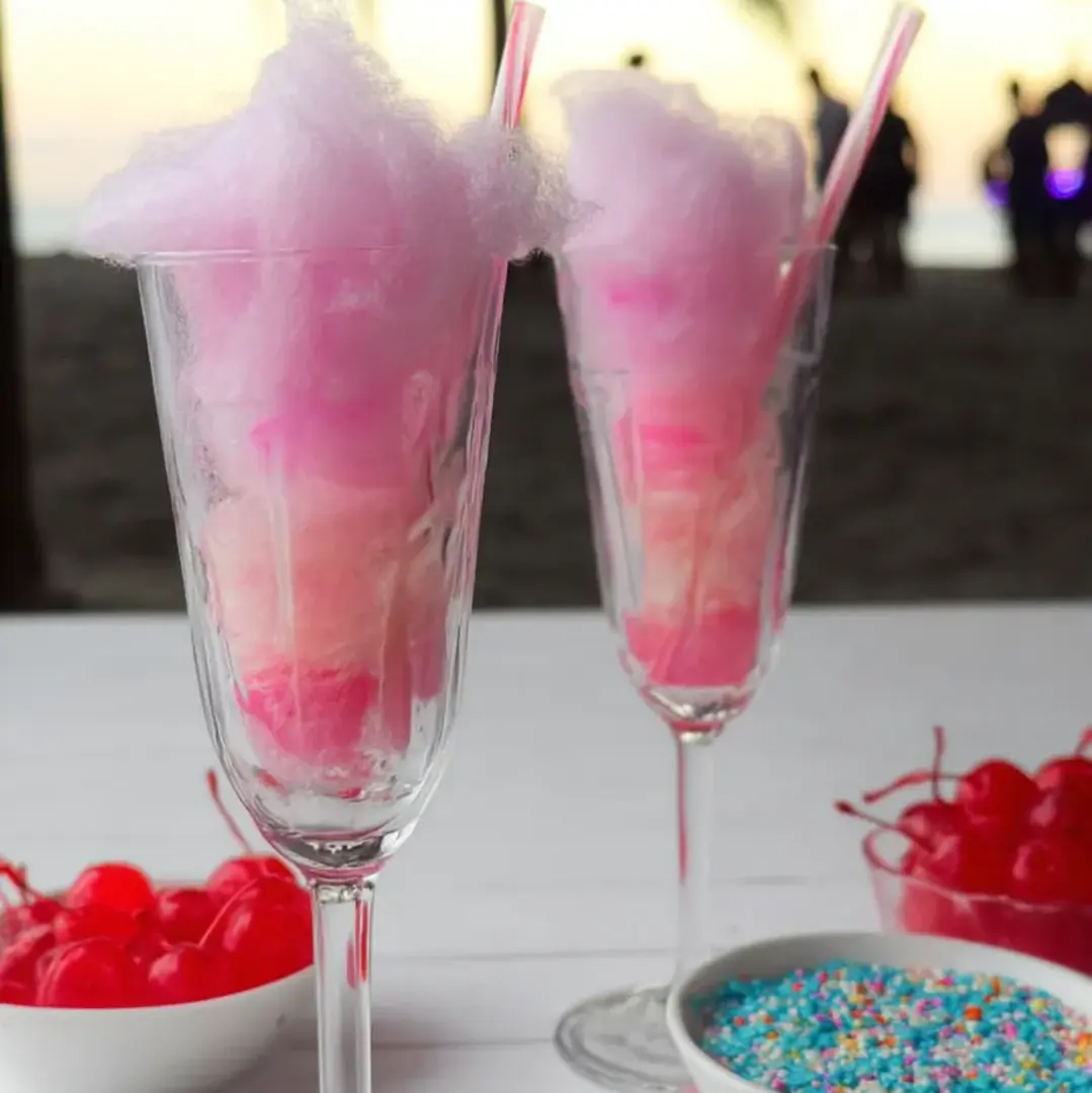 Fluffy pink cotton candy stacked inside a pair of glasses.