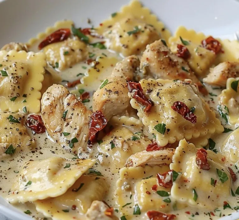 A plate with pasta, chicken, and some red veggies on top.