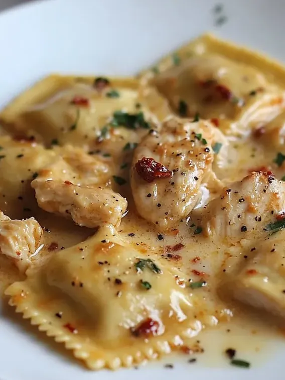 A big plate of pasta piled with chicken and creamy sauce.