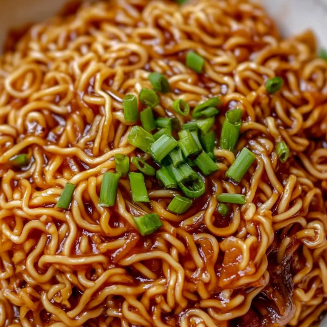 Bowl piled with ramen and sliced green onions.