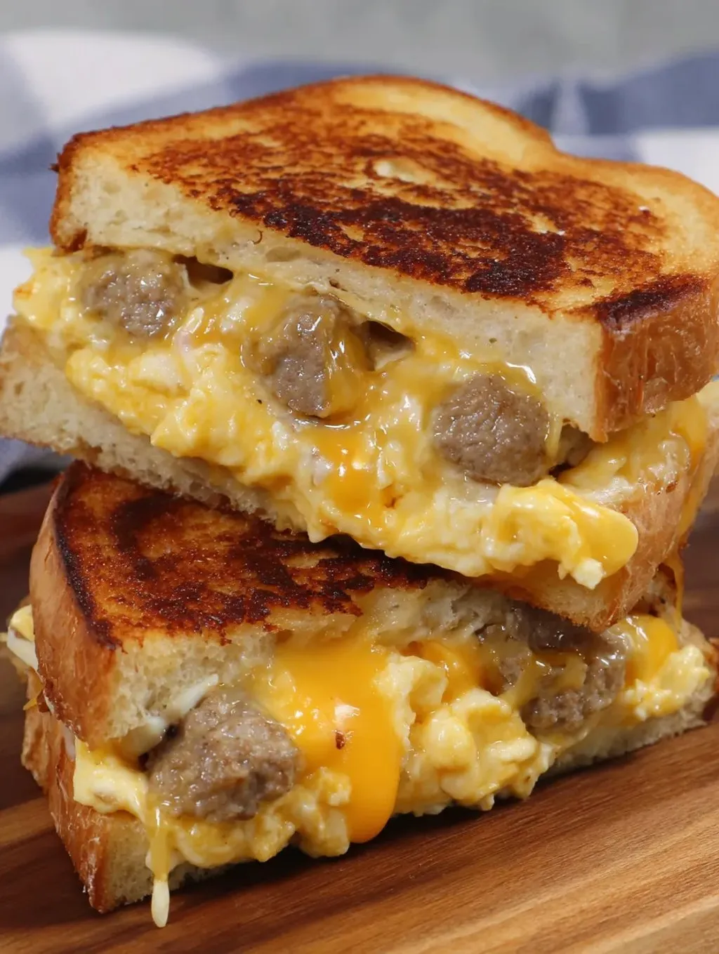 A sandwich oozing cheese and sausage.