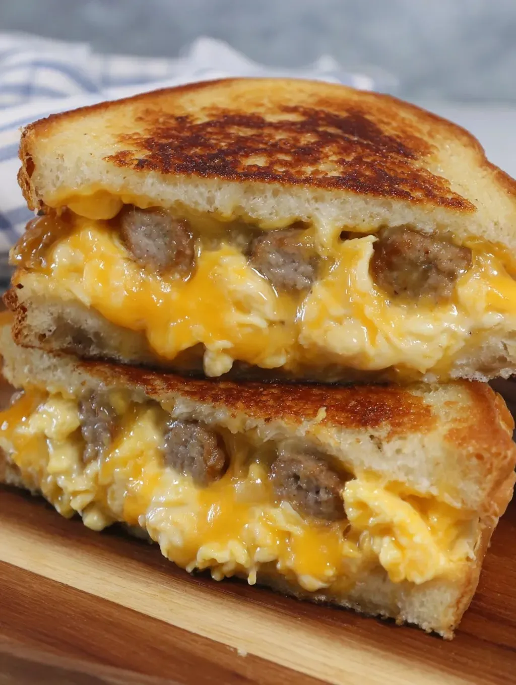 A cheesy sandwich with sausage on a plate.