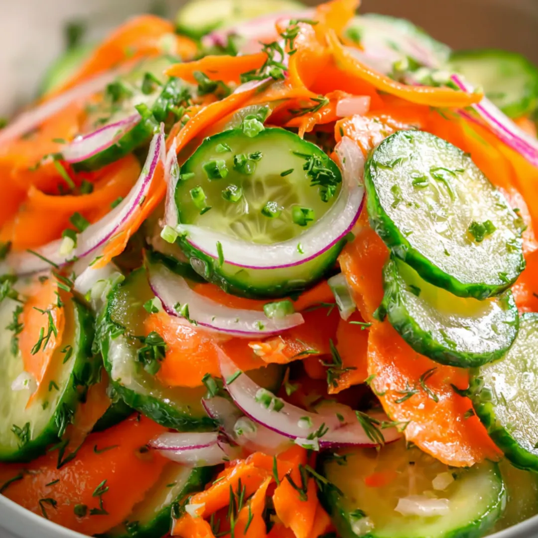 Carrots, cucumbers, and onions tossed together in a bowl.