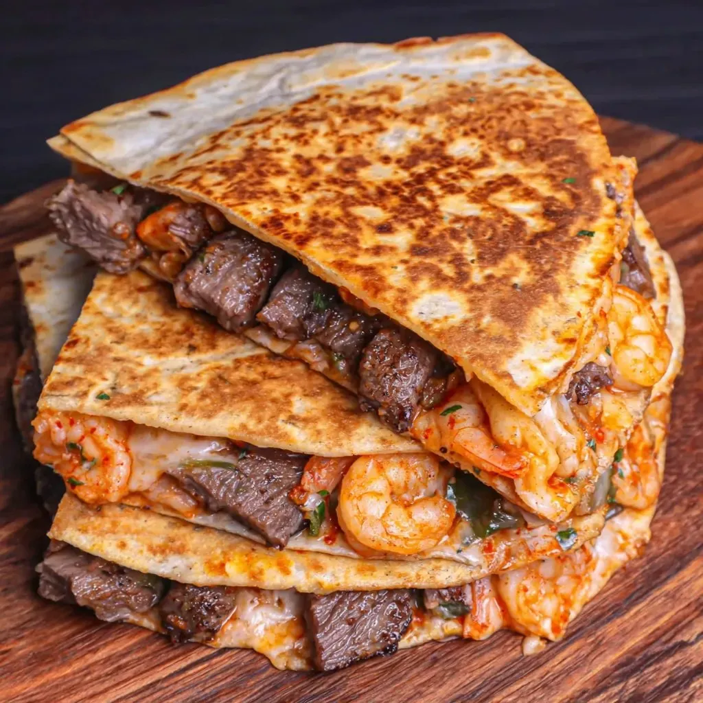 A stack of beef and shrimp tacos.