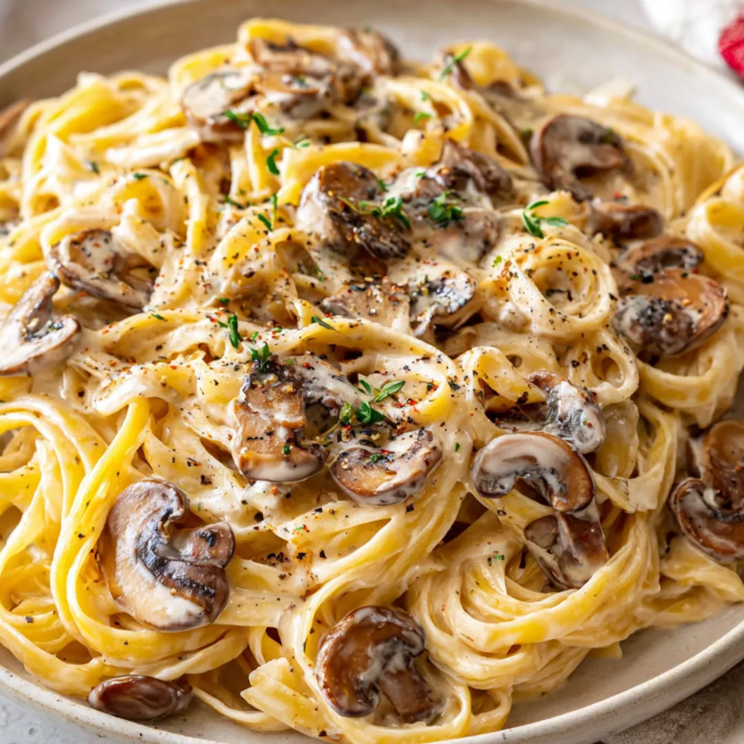 A bowlful of fettuccine with mushrooms and cheese.