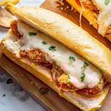 A sandwich with meat and cheese on a wooden table.