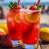 Bright red strawberry lemonade in two glasses with slices of lemon, sitting on a table.