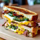 A sandwich loaded with peppers, cheese, and savory bacon.