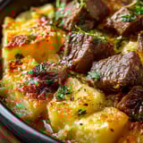 A bowl of meat and potatoes.