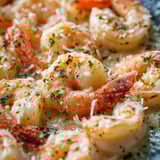 A plate piled with shrimp and scallops.