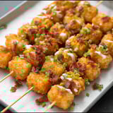 Appetizers with bacon wrapped around them, all arranged on a baking tray.