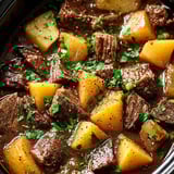 Beef stew with potatoes and green onions in a bowl