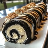 A plate showing a chocolate roll cake and a slice of cake.