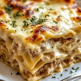 A stack of lasagna with cheese and meat.